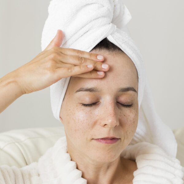 close up woman applying cream her face